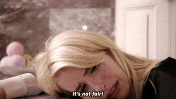 TV gif. Emma Roberts as Chanel Oberlin in Scream Queens, her mascara dripping from her eyes, cries, "It's not fair!" which appears as text, before slumping her head onto her arms on a countertop.