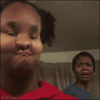 Video gif. Mother reacts in horror to a filter on her child’s face that makes her mouth and nose look pinched, then the child zooms in on her mom’s face, and her face takes on the filter, pinching her already horrified look.
