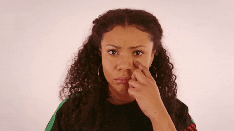 Video gif. Woman stares at us with a sad face. She moves her finger down her cheek to draw a tear down her face.