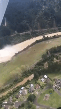 Floodwater Cascades From Dam Upstream From Inundated New Zealand Town