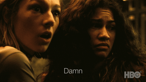 TV gif. Hunter Schafer as Jules in Euphoria looks in shock as she turns to Zendaya as Rue who frowns and says, "Damn."