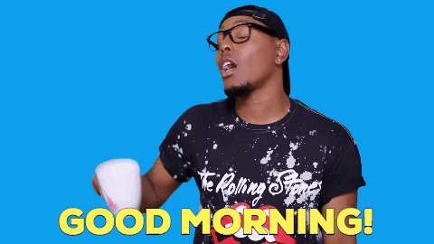 Video gif. A man says, "Good Morning," while raising a mug of coffee and pulling back, looking sassy and expectant for a reply.