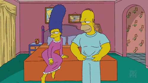 The Simpsons gif. Wearing a nightgown, Marge watches on the edge of the bed in anticipation as Homer removes his shirt, revealing a chiseled chest and abdomen before flexing his biceps in her direction. Marge responds excitedly, curling her toes and bringing her hands to her chest as she says, “Ooohh!”