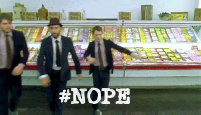 Video gif. Three men in suits dance, crossing their feet over one another like they’re dancing in a Broadway show, in a grocery store. Text, “hashtag nope.”