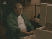Celebrity gif. Drew Carey sits at an old blocky desk computer. He has his hands on the keyboard and then he shakily pulls his hands close to his face as he looks at the computer screen with fear.