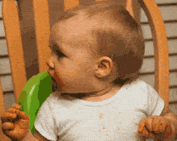 Video gif. Baby in a high chair with red sauce smeared around his mouth sneezes, and a spaghetti noodle shoots out of a nostril.