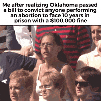 Meme gif. Woman in an outdoor crowd, wearing a white tank top and visibly sweating, curls her fingers into her hands and flails her arms around angrily, straining as she screams and shouts. Text, "Me after realizing Oklahoma passed a bill to convict anyone performing an abortion to face ten years in prison with a one-hundred-thousand-dollar fine."