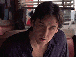 Celebrity gif. A frustrated and annoyed John Cusack shakes his head and shrugs in exasperation.