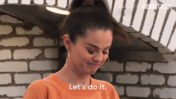 Reality TV gif. Selena Gomez on Selena and Chef leans over the counter and excitedly says, “Let’s do it.”