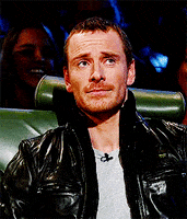 Celebrity gif. Michael Fassbender reacts to something in surprise, raising his eyebrows and taking a deep breath.
