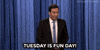 Tonight show gif. Jimmy Fallon stands in front of his blue curtain and says uncertainly, "Tuesday is a fun day!," which appears as text. He moves his arms up and down, as if he's weighing his options.