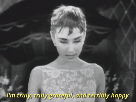 Celebrity gif. Audrey Hepburn accepts an Academy Award. She nods her head with a big smile on her face as she says, “I'm truly, truly grateful, and terribly happy.”