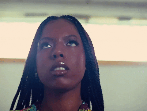 Music video gif. Woman from A$AP Rocky's music video for Designer Boi is rolling her eyes and looks away as paparazzi takes her photo.