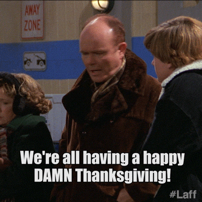 TV gif. Kurtwood Smith as Red Forman, Debra Jo Rupp as Kitty Forman, and Topher Grace as Eric Forman on That 70s Show stand outside  in heavy coats. Kitty shivers as Red angrily yells to Eric, “We're all having a happy damn Thanksgiving!” 