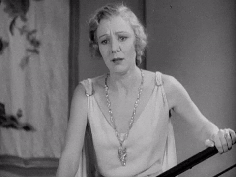Movie gif. Black and white shot of Kay Johnson as Mrs. Angela Brooks in Madam Satan holds a stair banister and dramatically drops her head to her arm as if reacting to horrifying sad news.