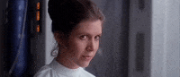 Movie gif. Carrie Fisher, as Princess Leia in Star Wars, reacts with a demure, pleased smile.