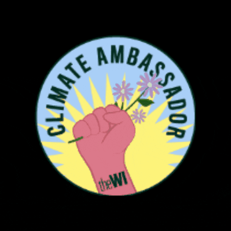 Digital art gif. Inside a blue circle, a pink fist clutches onto a bouquet of three light purple daisies. Green text reads, "Climate Ambassador."