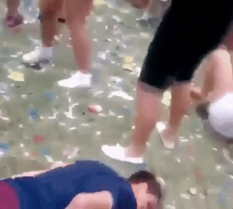 Video gif. A deeply drunk man does the worm on a confetti littered floor. He worms his way to a couple sitting on the ground and accidentally headbutts them, which causes him to fall over. 