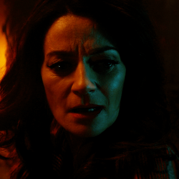 TV gif. Michelle Gomez as Madam Satan on Chilling Adventures of Sabrina is in a dark room and is lit up by a fire behind her. She gasps in excitement and looks down as she says, “Perfect.”