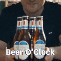 Sponsored gif. Man pushes four bottles of Michelob ULTRA beer forward across a counter. Text reads, “Beer o’clock.”
