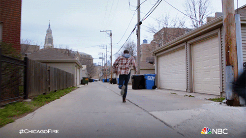 TV gif. On Chicago Fire Taylor Jackson as Kelly chases man down an alley, gaining on him quickly.
