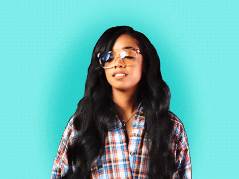 Celebrity gif. H.E.R is standing with a comfy flannel and glasses on. She takes a deep breath and sighs, letting her shoulders droop down as she rolls her eyes.