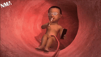 Digital art gif. A fetus sits inside the womb, singing into a microphone and holding a cell phone, wearing fashion glasses.