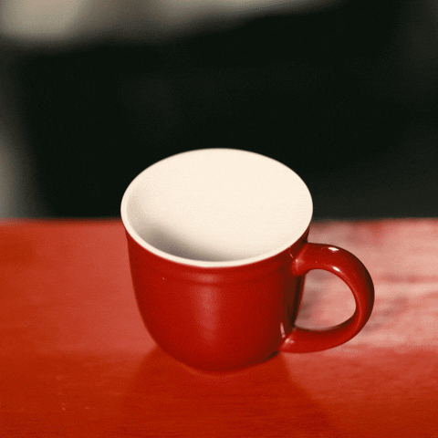 Video gif. A carafe pours coffee into a red mug, which immediately begins to disappear slowly.
