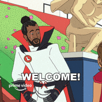 Cartoon gif. Dressed in a white coat and a red-and-black cape, Hiroki Hassan from Fairfax opens his arms and smiles, saying "Welcome!" which appears as text.