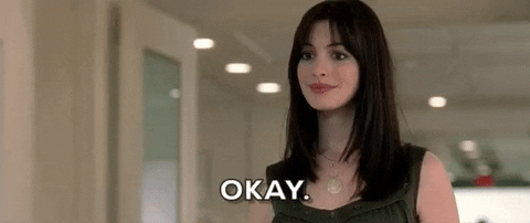 Movie gif. Anne Hathaway as Andrea Sachs in The Devil Wears Prada smiles, "Okay."