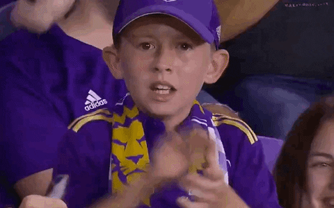 Video gif. Young boy shakes his head intently as he mouths the words, "Let's go," clapping his hands fiercely and throwing a fist in the air.