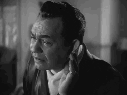 Movie gif. Edward G. Robinson in Johnny Rocco. He puts a hand to his ear to listen closely and he makes an expression and sound of understanding before leaning back and nodding.
