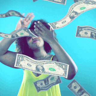 Video gif. Jasmyn Lawson tilts her head back and brushes one hand with the other as dollar bills drift down from above.