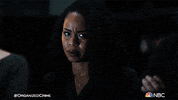 TV gif. Danielle Mone Truitt as Ayanna looks over at Christopher Meloni as Elliot on Law & Order: Organized Crime. She has a concerned look on her face as he turns away from her to look down grimly. 