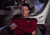 TV gif. Jonathan Frakes as Riker in Star Trek sits in a chair with his arms crossed and he's visibly annoyed as he sighs and prepares to get up.