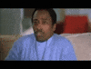 Video gif. Man sits on a couch, his eyes glued to something as he takes a handful of popcorn and shoves it in his mouth. Popcorn falls out of his hand as he chews quickly.