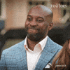 Sponsored gif. Traitors cast member Jeremy Collins begrudgingly scrunches his face in happiness.