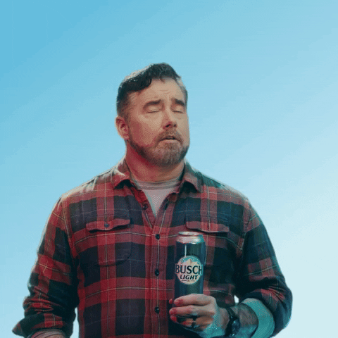 Sponsored gif. Gerald Downey in a red and black plaid shirt slowly wipes his brow with a can of cold Busch Light beer like he's really enjoying the moment. He nods and looks releived as he smiles and gives a cheers. Text, "Phew!"