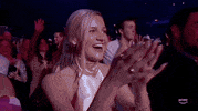 ACM Awards gif. Woman excitedly glances from one side to another as she claps.