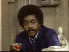 TV gif. Demond Wilson, sitting down with a drink, laughs hard and points at us.