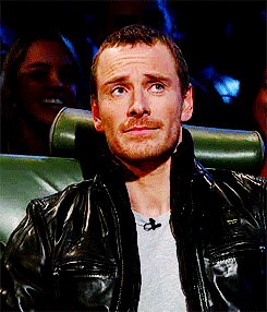 Celebrity gif. Michael Fassbender reacts to something in surprise, raising his eyebrows and taking a deep breath.