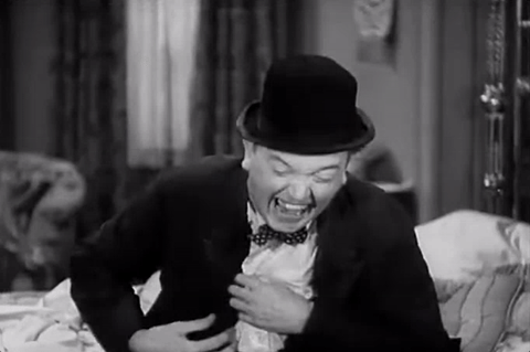 Movie gif. Stan Laurel in Way Out West is laughing hysterically. He fixes his coat and tries to catch his breath, but can’t stop laughing.