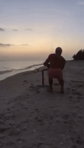 Strong Fisherman Runs on Beach to Reel in Shark