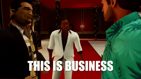 Video game gif. Lance "Vance" Wilson from "Grand Theft Auto Vice City" gestures towards two men dressed in stylish shirts that look back at him with serious expressions. Text, "This is business."