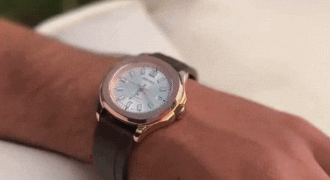 A wristwatch with a brown leather band showing time on a person's wrist.