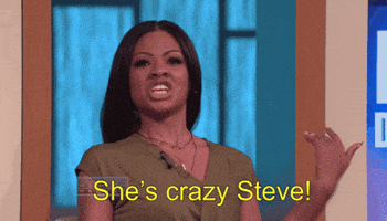 Reality TV gif. Steve Harvey winces as a woman yells at him with flailing arms. Text, "She's crazy Steve!"