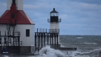 Waves Crash Into Michigan Lighthouse as Cool Air Moves Across Region