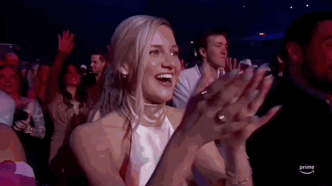 ACM Awards gif. Woman excitedly glances from one side to another as she claps.