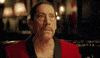 Ad gif. Actor Danny Trejo in a Magic the Gathering commercial sits at a restaurant table in a red velvet smoking jacket. He kisses his finger tips in a gesture expressing perfection. 