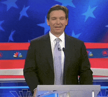 Video gif. Ron DeSantis stands at a podium during a presidential debate. He laughs to himself then looks to the side with an uncomfortable, somewhat uncertain expression. Subtitle text reads, "That's not true." 